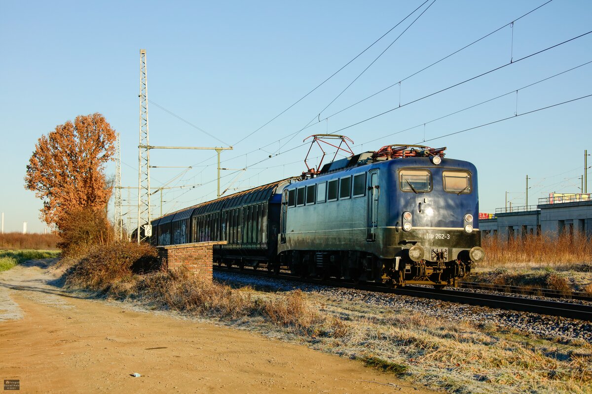 110 262-3 BayernBahn mit Henkelzug in Köln Porz Wahn, Dezember 2021.
