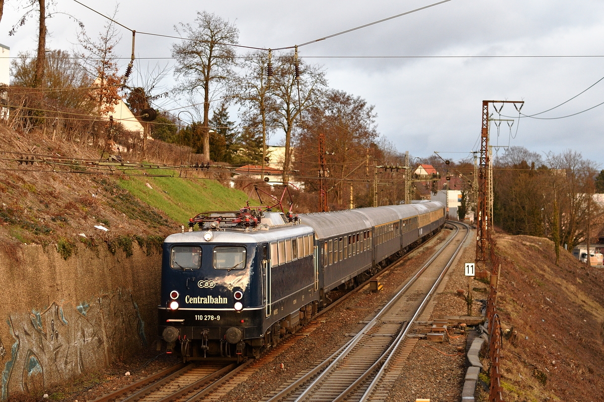110 278 von Centralbahn bespannte am 1. März 2019 einen Fußballsonderzug von Dortmund nach Augsburg. Gleich unterquert sie den Syrlinsteg in Ulm. 