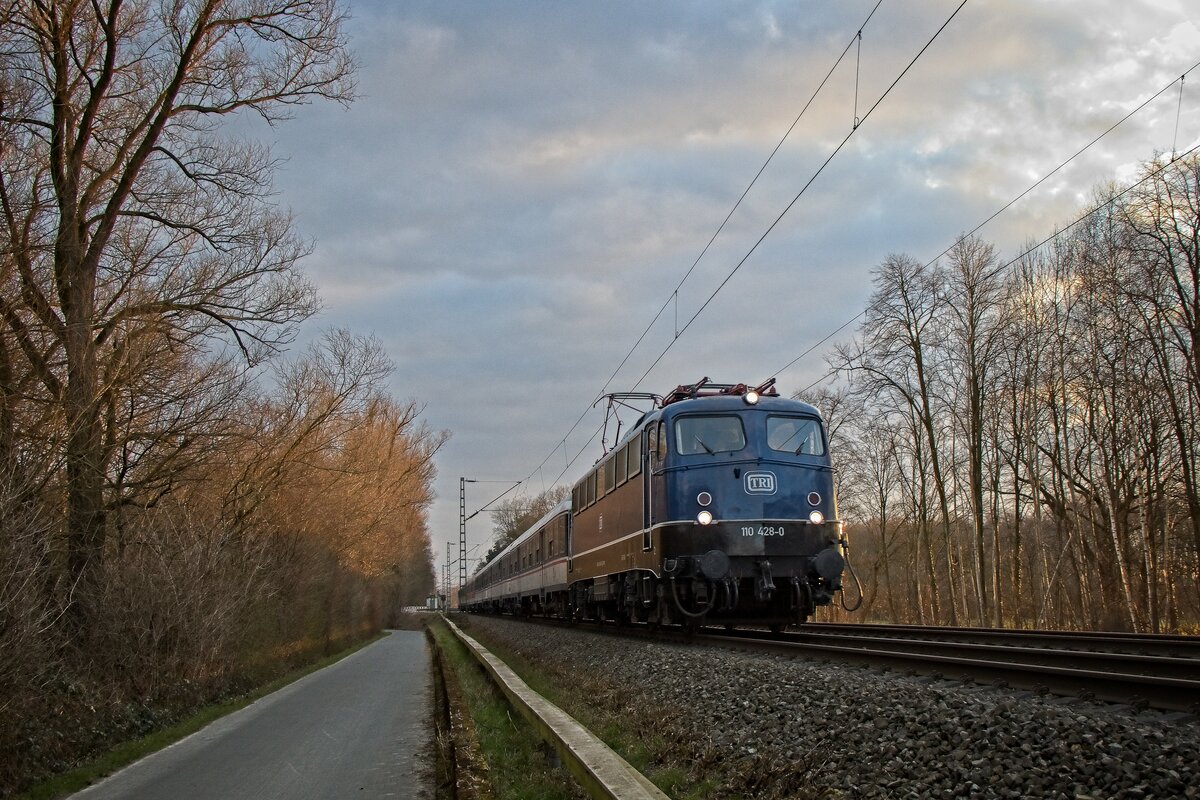 110 428-0 der TRI kehrt mit einem Fußball-Sonderzug aus Wuppertal-Sonnborn nach Münster zurück und passiert im Abendlicht Unna-Mühlhausen (06.03.2022)