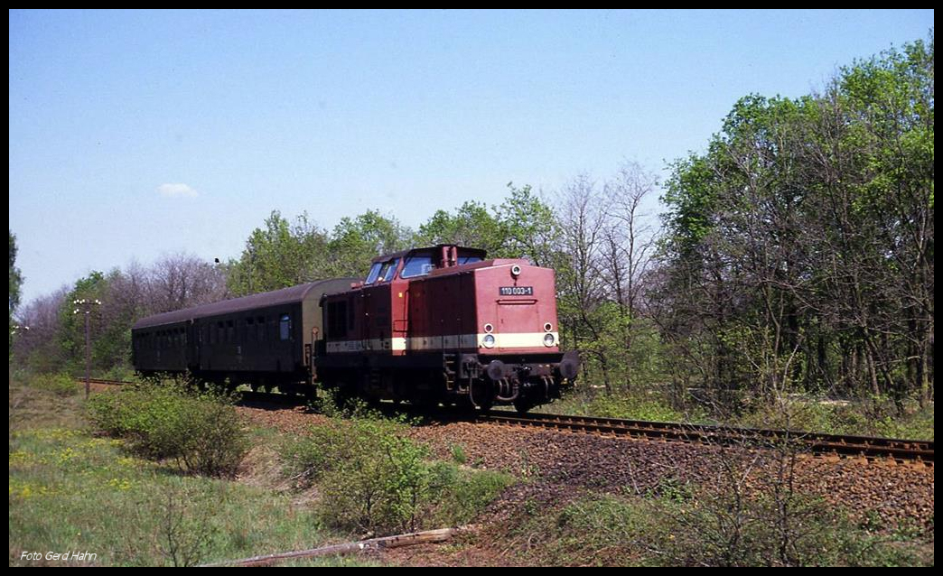 1100003 ist hier am 5.5.1990 am Bahnübergang bei Merschwitz kurz vor Pretzsch mit einem Personenzug aus Lutherstadt Wittenberg auf der KBS 218 unterwegs.