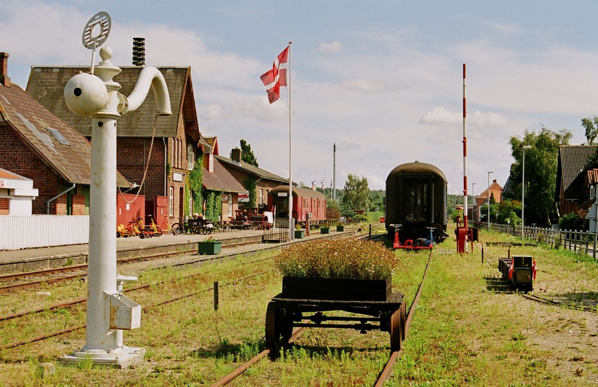 11.08.2004 Dänemark, der Bahnhof Allingabro. Nach der Besichtigung verschiedener Relikte kann man auf der stillgelegten Strecke zu einer Draisinenfahrt nach Pindstrup starten.