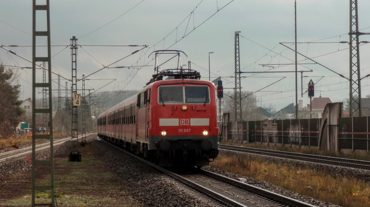 111 007, die älteste 111er von DB Regio, erreicht mit einer RE 70 Garnitur die aus 6 n-Wagen besteht den Bahnhof Lampertheim. Aufgenommen am 30. November 2017.