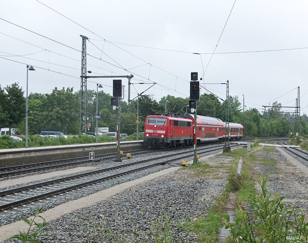 111 023 mit einer RB nach Landshut bei der Einfahrt in Moosburg: Außergewöhnlich ist hier die Zugbildung aus einem Doppelstockwagen und Wittenberger Steuerwagen, die so im Juni und Juli 2013 einige Wochen auf der KBS930 unterwegs war. Aufgenommen am 29.6.2013 in Moosburg.