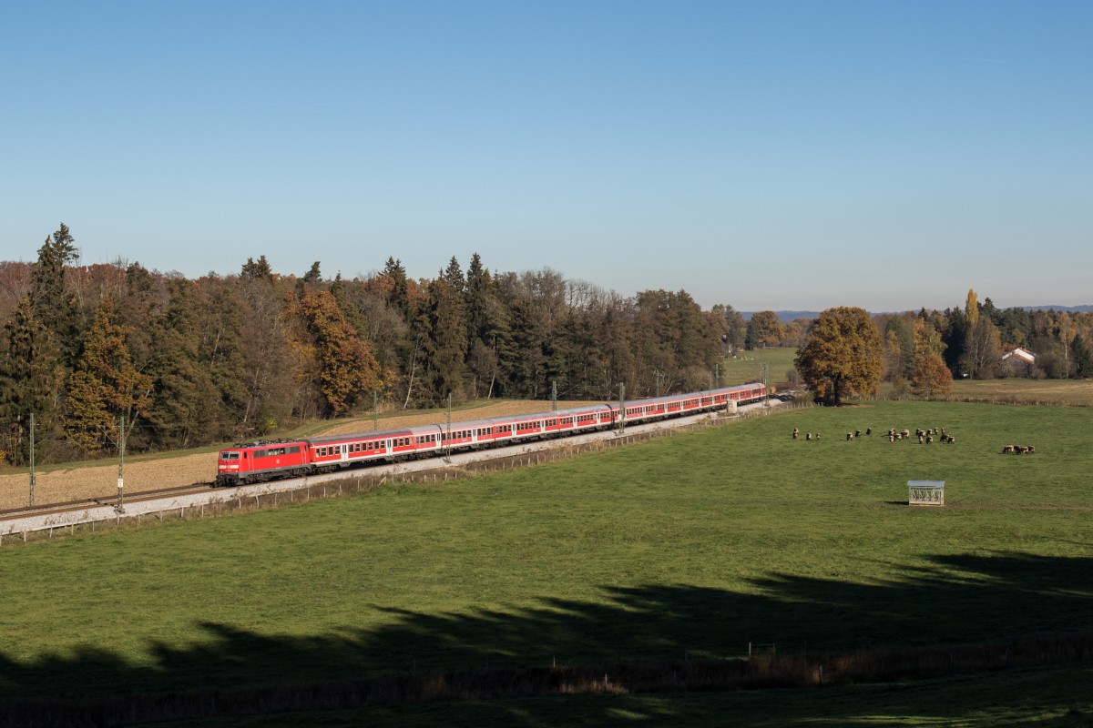 111 023 schiebt ihren Flüchtlingszug durchs Chiemgau - hier zu sehen kurz vor Übersee am 3. November 2015.