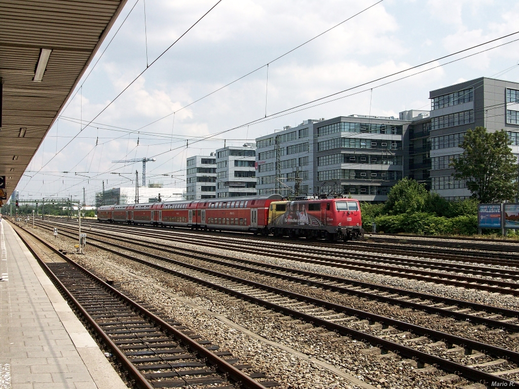 111 024, zum Zeitpunkt der Aufnahme noch ADAC-Werbelok, durchfährt am warmen 10.7.13 mit einer Regionalbahn aus Treuchtlingen den Bahnhof München-Laim und erreicht in Kürze den Endbahnhof München Hbf.