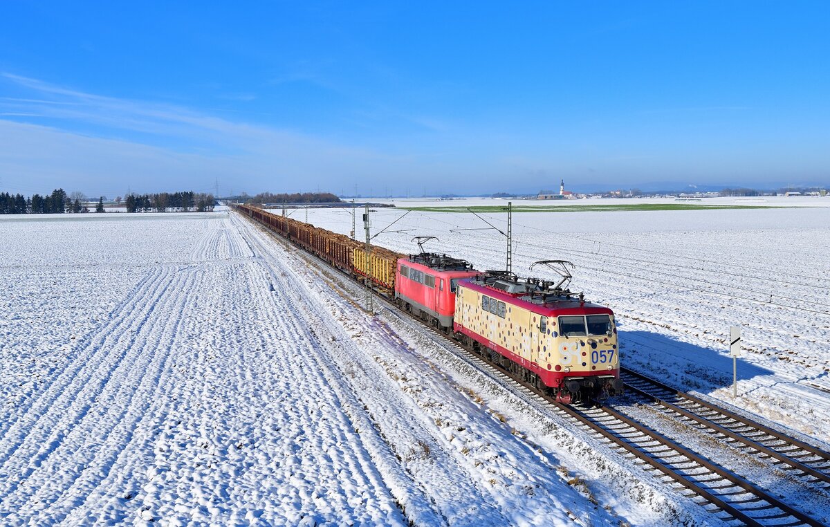 111 057 + 111 216 mit einem Holzzug am 10.12.2021 bei Stephansposching.