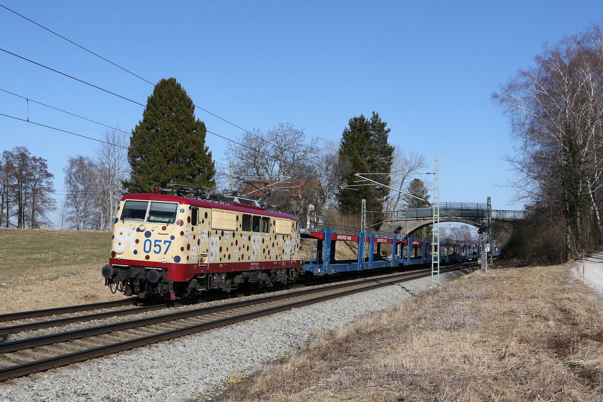 111 057 von  Smartrail  mit einem leeren Autozug aus Freilassing kommend am 8. März 2022 bei Übersee am Chiemsee.