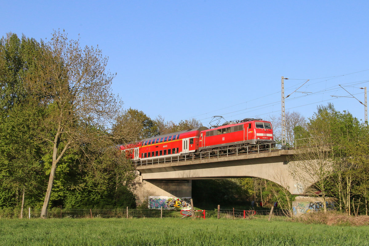 111 067 der Deutschen Bahn AG, die ehemals in Stuttgart beheimatet war und noch das  Bwegt -Logo trägt, war am 20. April 2020 mit dem Regionalexpress 10454 von Düsseldorf Hauptbahnhof nach Aachen Hauptbahnhof unterwegs und überquert hier die Rur bei Brachelen.
