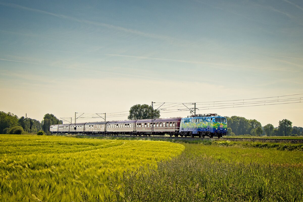 111 074 zieht am Abend des 22.05.2022 einen Touristikzug durch die Selmigerheide in Richtung Rheine 
