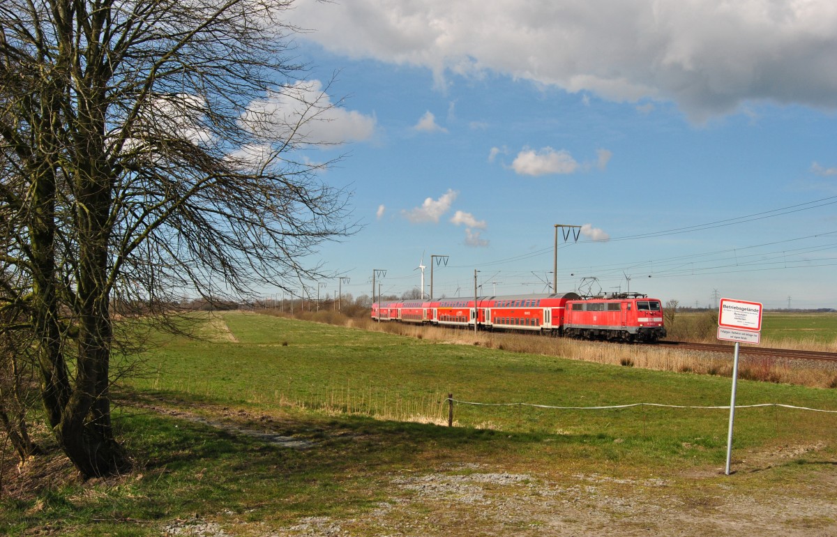 111 089 fuhr am 04.04.2015 mit einem RE von Emden nach Münster, hier bei Petkum.