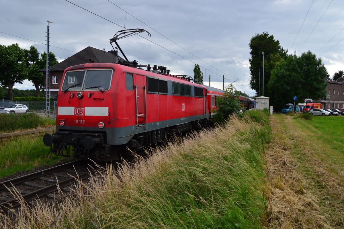 111 112 schiebt einen RE4 Verstärkerzug nach Aachen Hbf, gleich wird der Zug in Herrath Halt machen. 23.6.2015