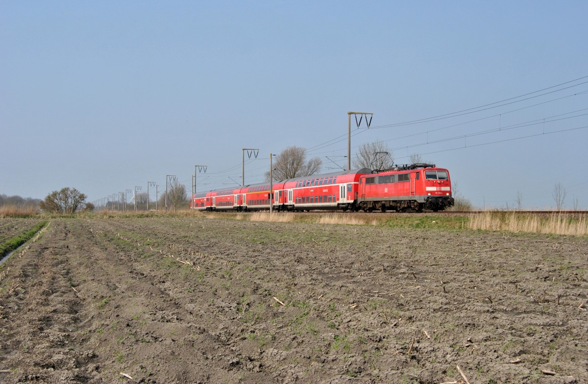 111 138-4 fuhr am 10.04.2015 mit einem RE von Emden nach Köln, hier bei Gandersum.