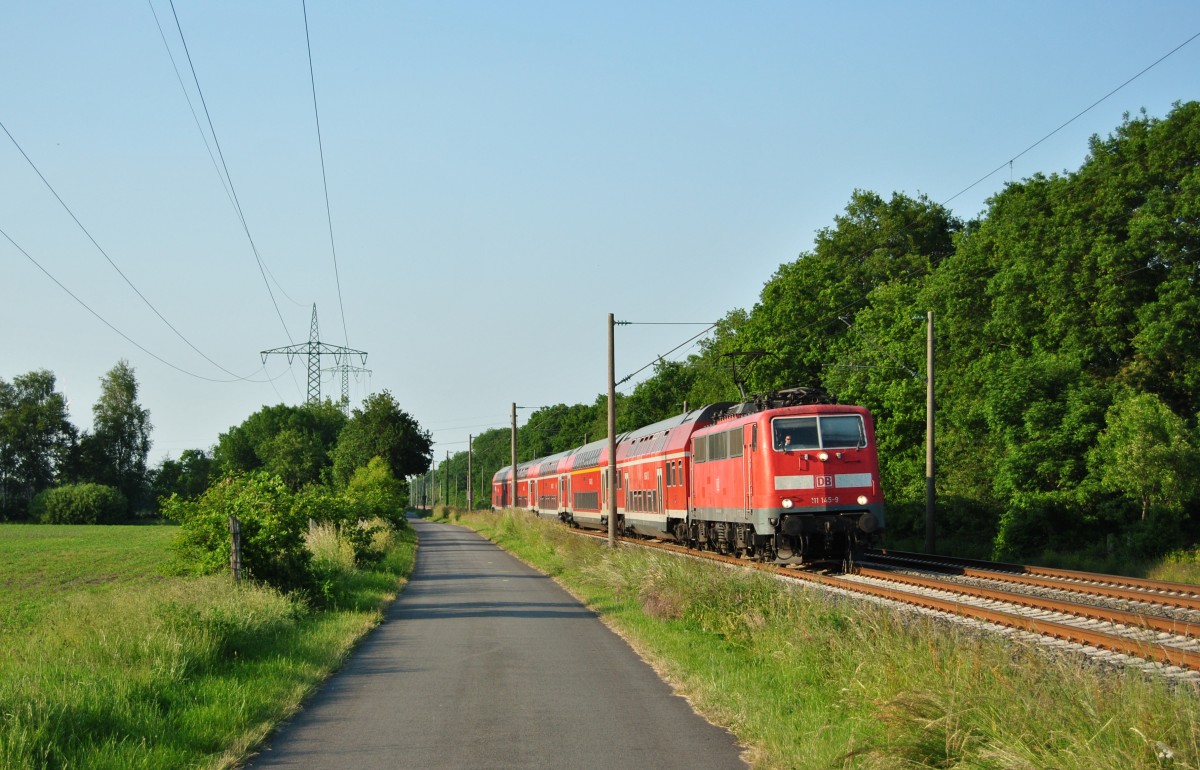 111 145-9 fuhr am 12.06.2015 mit einem RE von Emden nach Münster, hier bei Völlenerfehn.