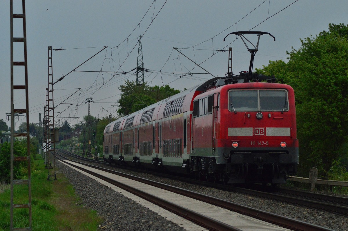 111 147-5 schiebt hier unweit des Bü Am Chur bei Wickrathhahn einen RE4 nach Dortmund. 26.4.2014