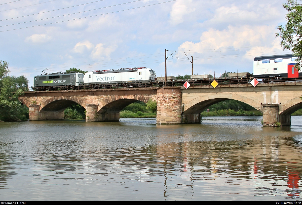 111 215-0 der RailAdventure GmbH überführt überraschend 193 837-2 (Siemens Vectron) der Siemens Mobility GmbH und zwei Wagen des RABe 502 (Bombardier Twindexx Swiss Express) SBB und überquert dabei die Saale bei Halle-Böllberg/Wörmlitz auf der Bahnstrecke Halle–Hann. Münden (KBS 590) Richtung Angersdorf.
[22.6.2019 | 14:36 Uhr]