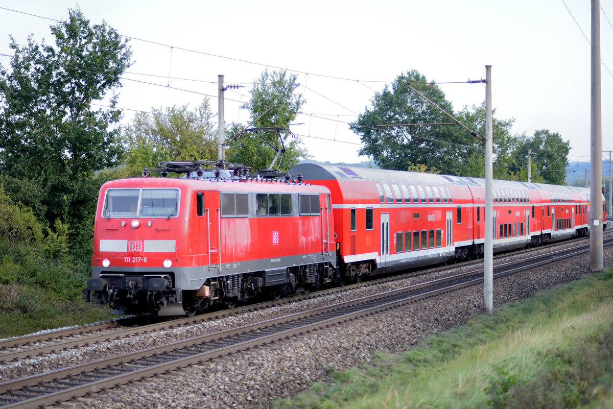 111 217-6 zieht ihre Doppelstockgarnitur, welche hauptsächlich von Berufspendlern genutzt wird, in Richtung Würzburg. Aufnahmedatum 01.10.2020