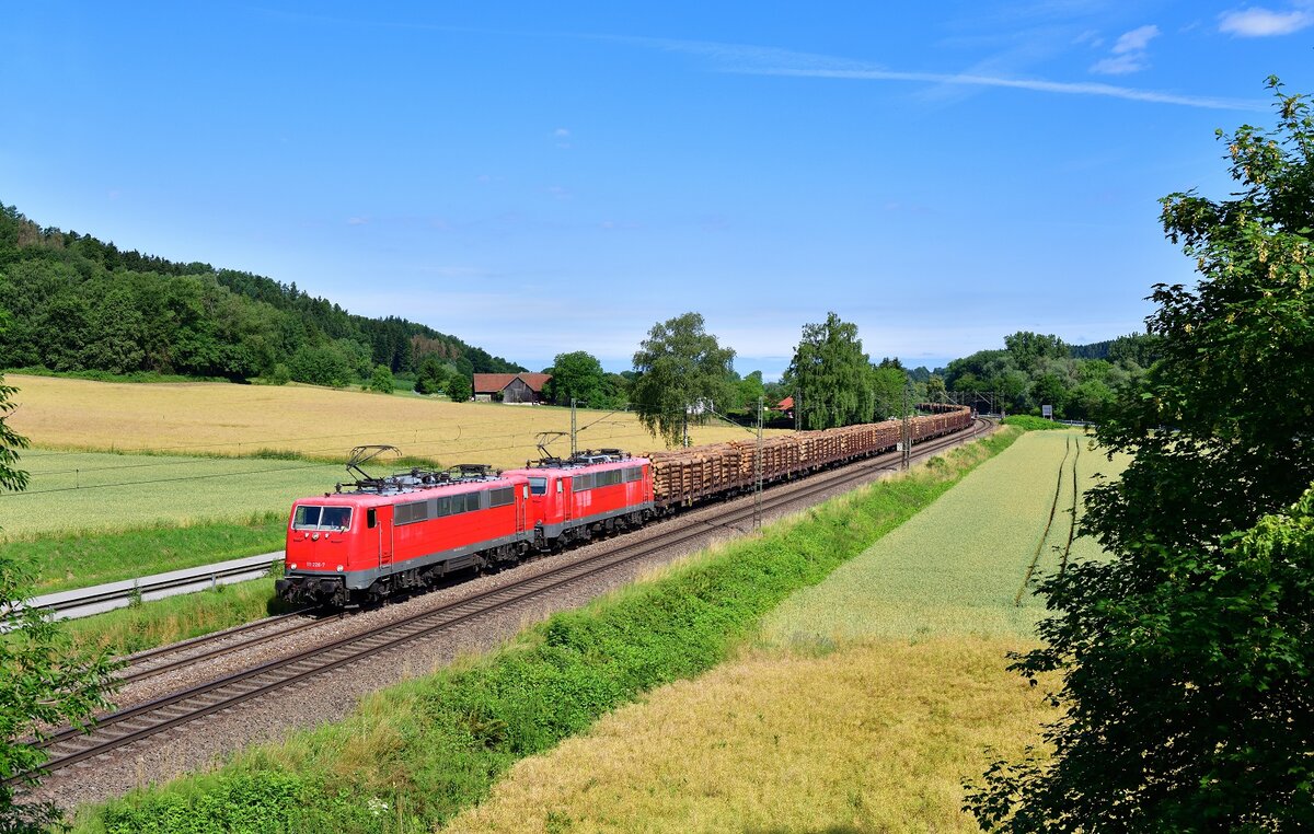 111 226 + 111 216 mit einem Holzzug am 08.07.2021 bei Einöd.