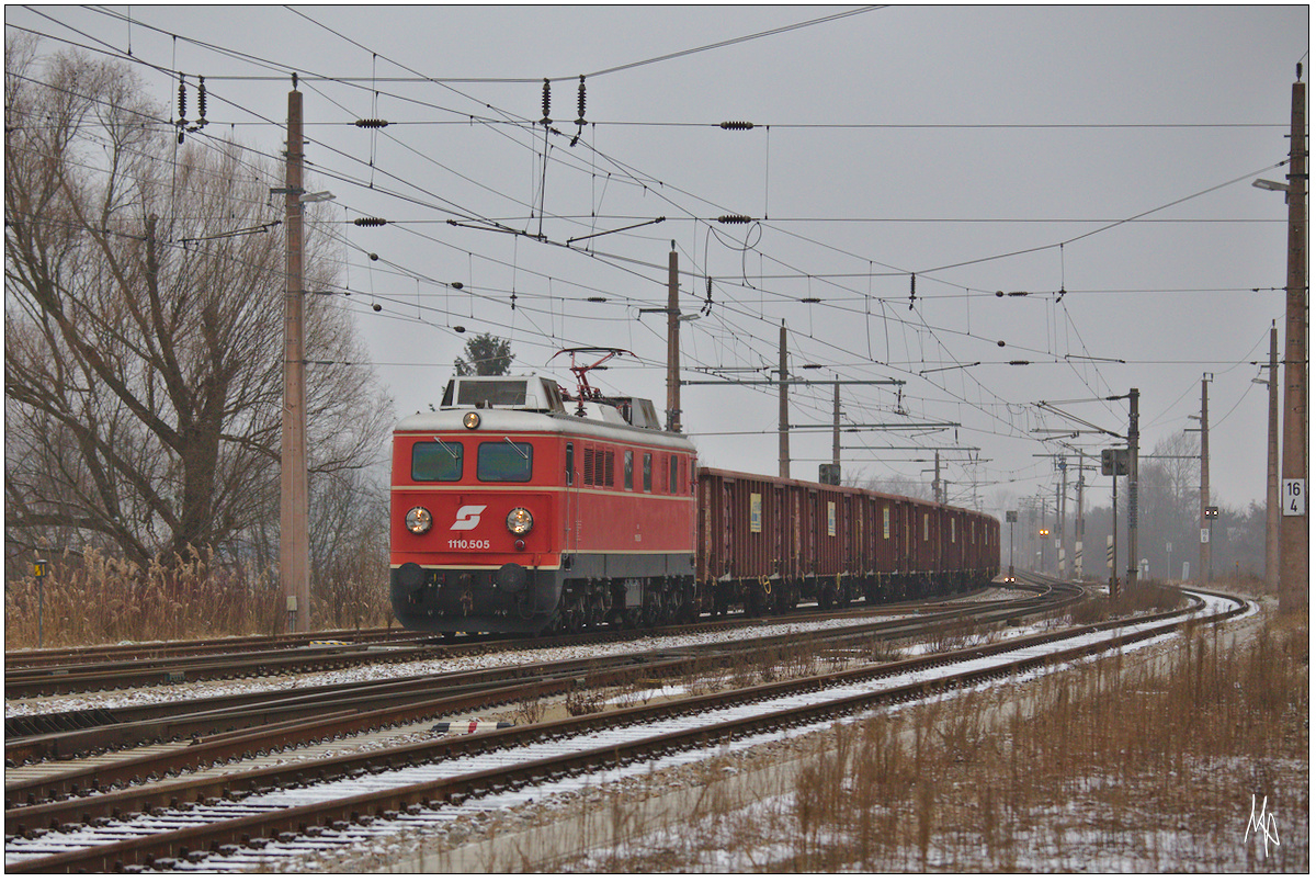 1110.505 mit ihrem Zug auf der Fahrt Richtung Wien, aufgenommen bei der Einfahrt in den Bahnhof Korneuburg. (22.12.2016)