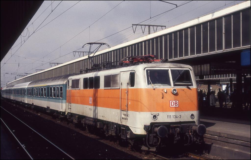 111134 in S-Bahn Lackierung steht hier am 19.4.1997 mit einer Nahverkehrsgarnitur am Bahnsteig im HBF Essen.