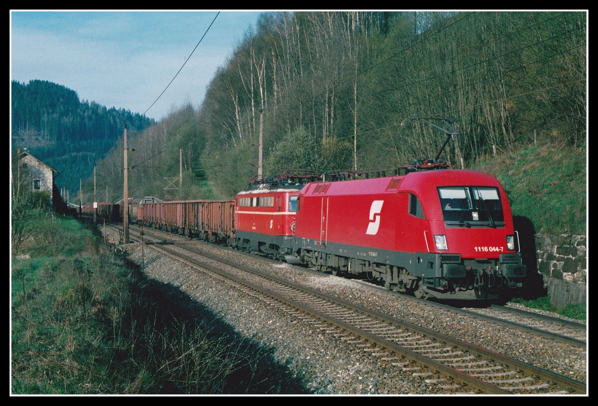 1116 044 + 1042 007 (geschleppt)fahren am 29.04.2003 mit G40480 bei Spital am Semmering Richtung Norden. Im Bild ist noch die alte Fahrleitung aus der Zeit der Elektrifizierung mit den orangenen Masten zu sehen. In der Zwischenzeit wurde die Fahrleitung erneuert und entspricht dem ÖBB-Standard.