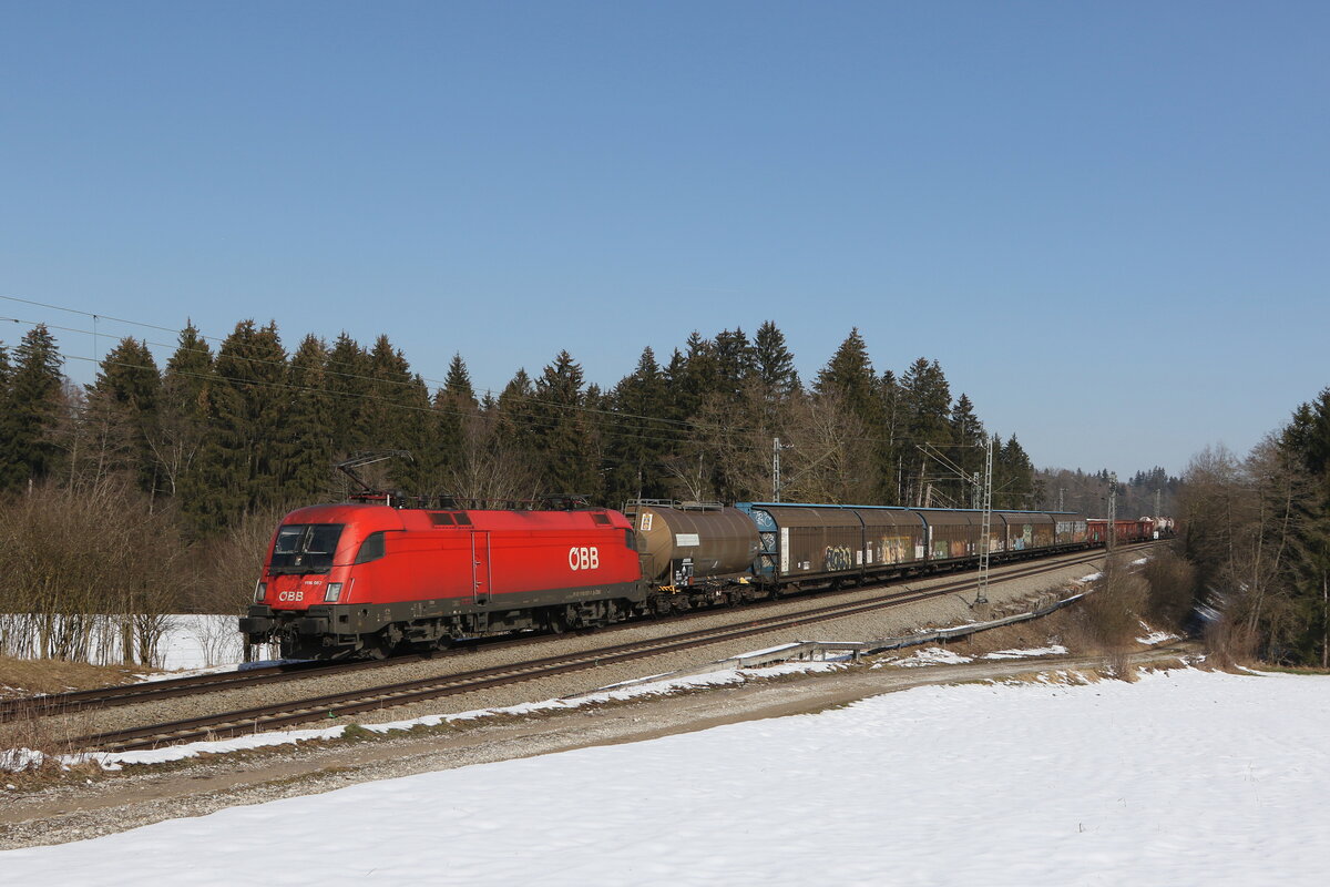 1116 057 mit einem gemischten Güterzug aus Salzburg kommend am 2. März 2023 bei Sossau im Chiemgau.