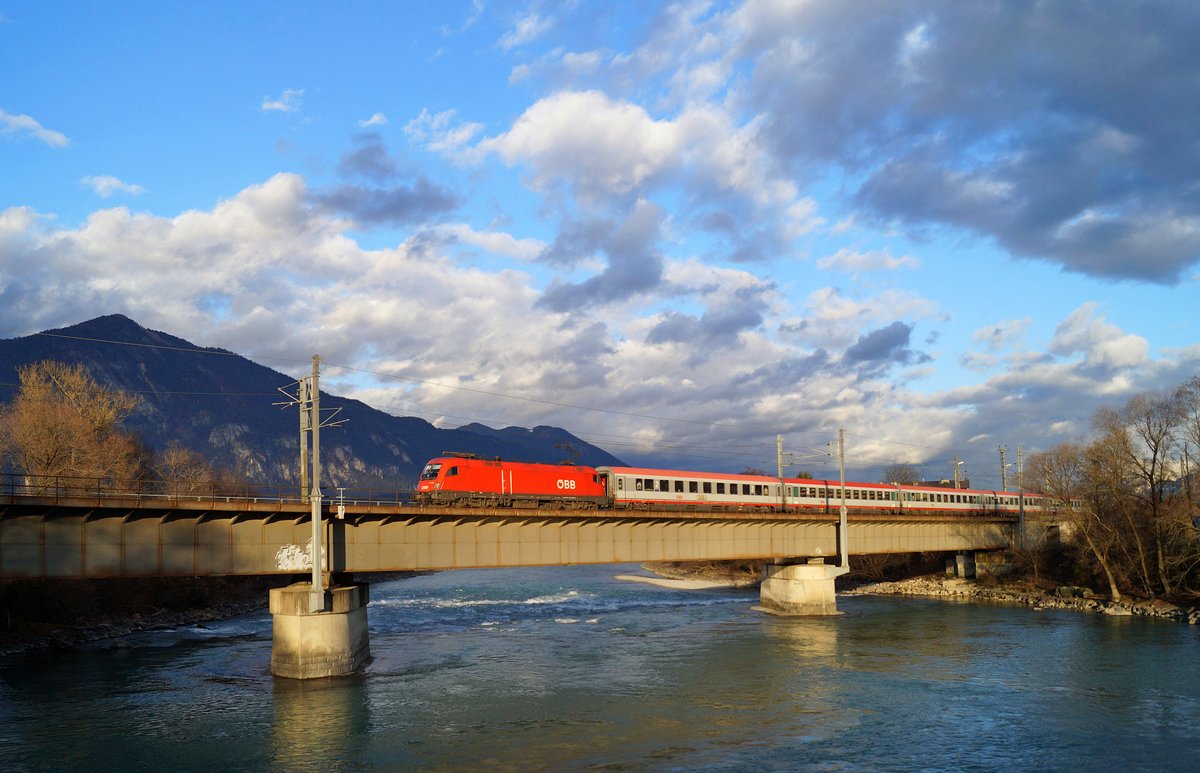 1116 066 befördert den EC 164  Transalpin  (Graz Hbf - Zürich HB) in der goldenen Abendsonne bei Brixlegg dem nächsten Halt Jenbach entgegen, 07.12.2019.