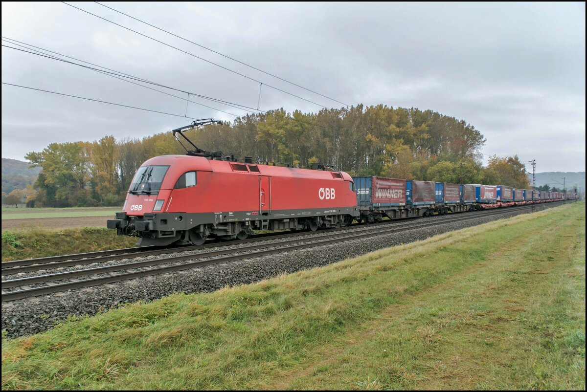 1116 095-1 ist am 27.10.2021 bei Himmelstadt mit einen Aufliegerzug in Richtung Süden unterwegs