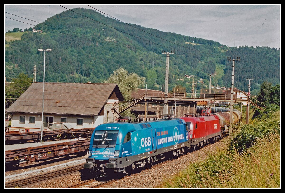 1116 100 + 1116 152 mit Güterzug sind am 19.06.2004 am Umfahrungsgleis des Brucker Frachtenbahnhos unterwegs.