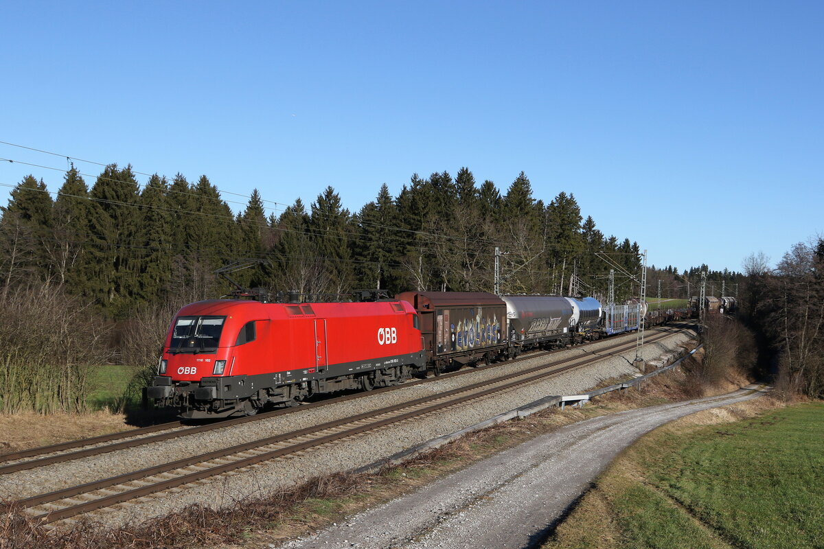 1116 102 mit einem gemischten Güterzug am 31. Dezember 2021 bei Grabenstätt.