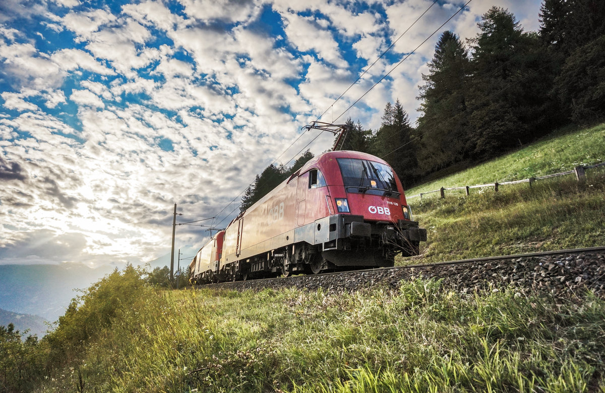 1116 120-7 und 1116 263-5 fahren mit einem Güterzug, kurz vor der Haltestelle Oberfalkenstein, die Tauernbahn-Südrampe hinunter.
Aufgenommen am 7.8.2017.