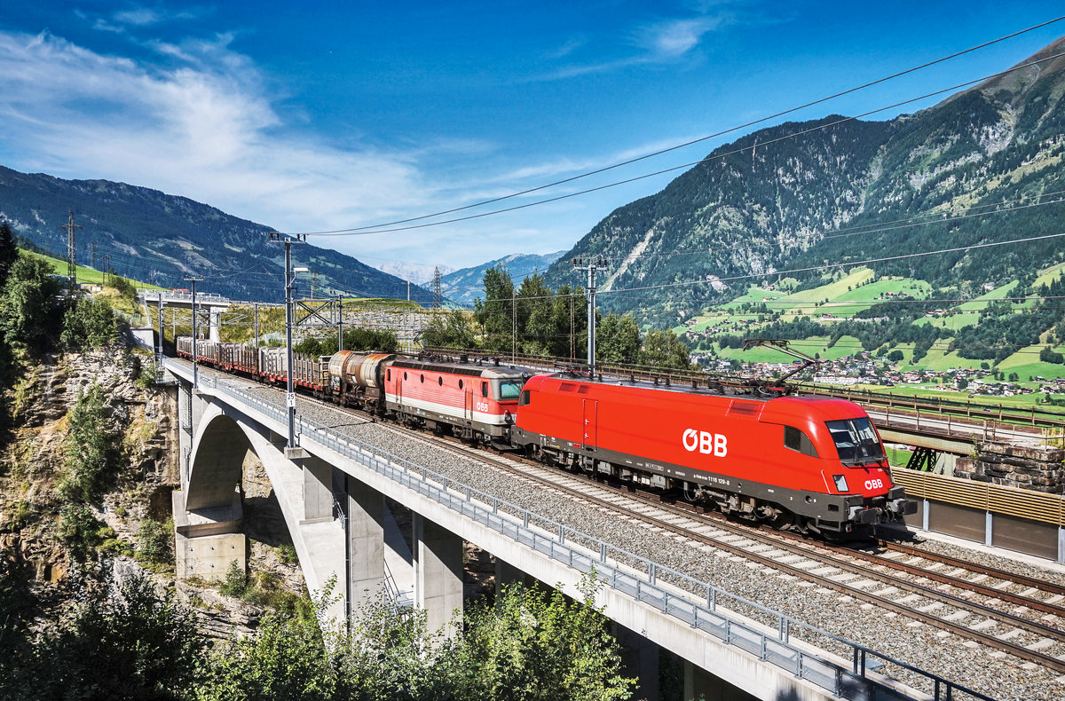 1116 129-8 und 1144 017-1 fahren mit einem Mischer, auf der neuen Angerschluchtbrücke, die Tauernbahn-Nordrampe hinauf.
Aufgenommen am 30.8.2017.