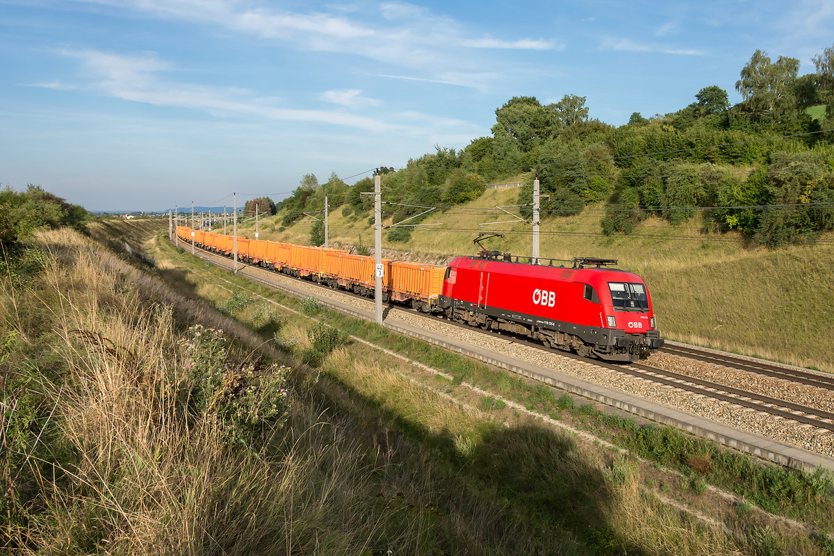 1116 129 mit einem Güterzug in der Abendsonne in Richtung Linz. Diendorf, am 09.08.2019.