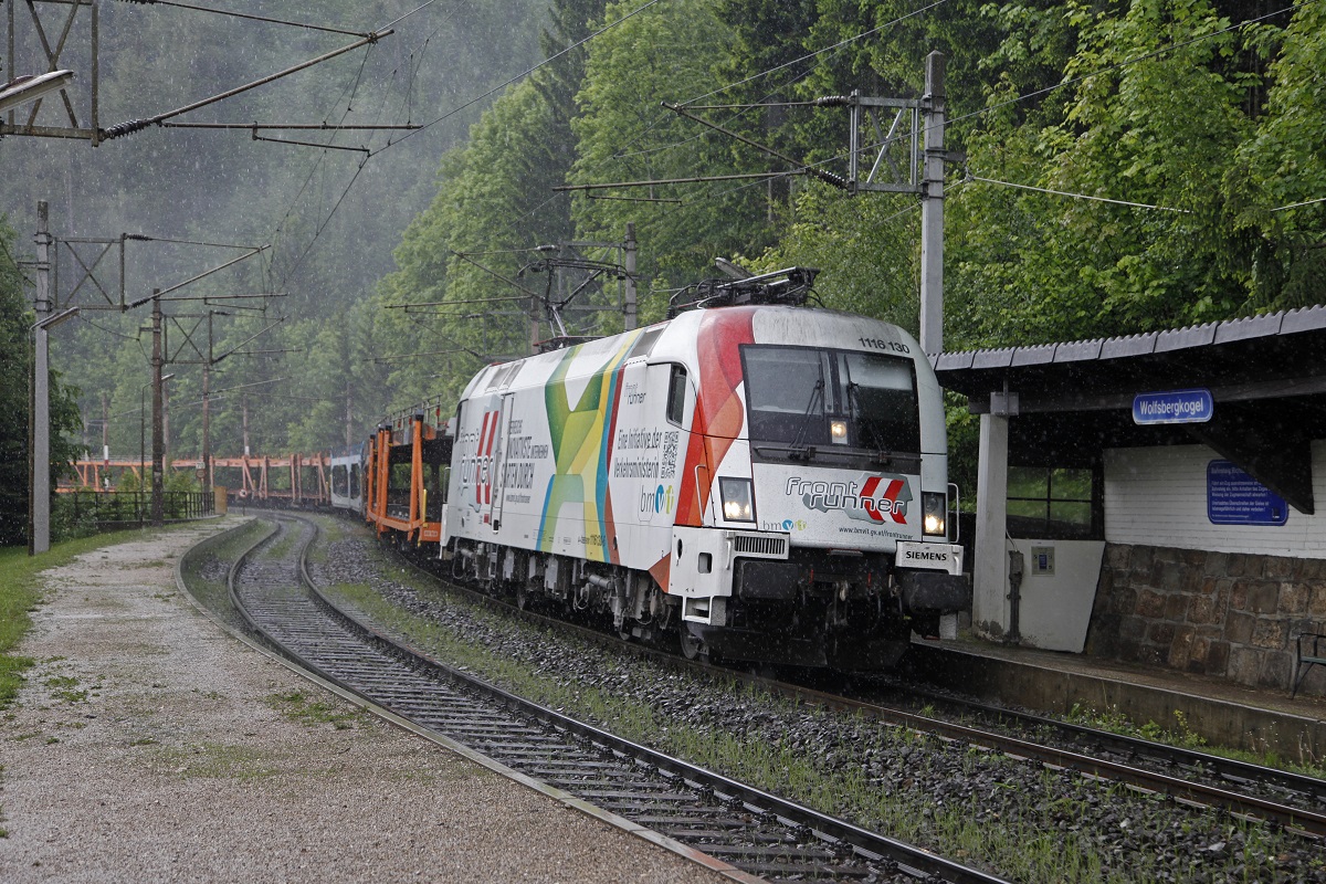 1116 130 (Frontrunner)fährt am 27.05.2014 mit einem Güterzug durch die Haltestelle Wolfsbergkogel.