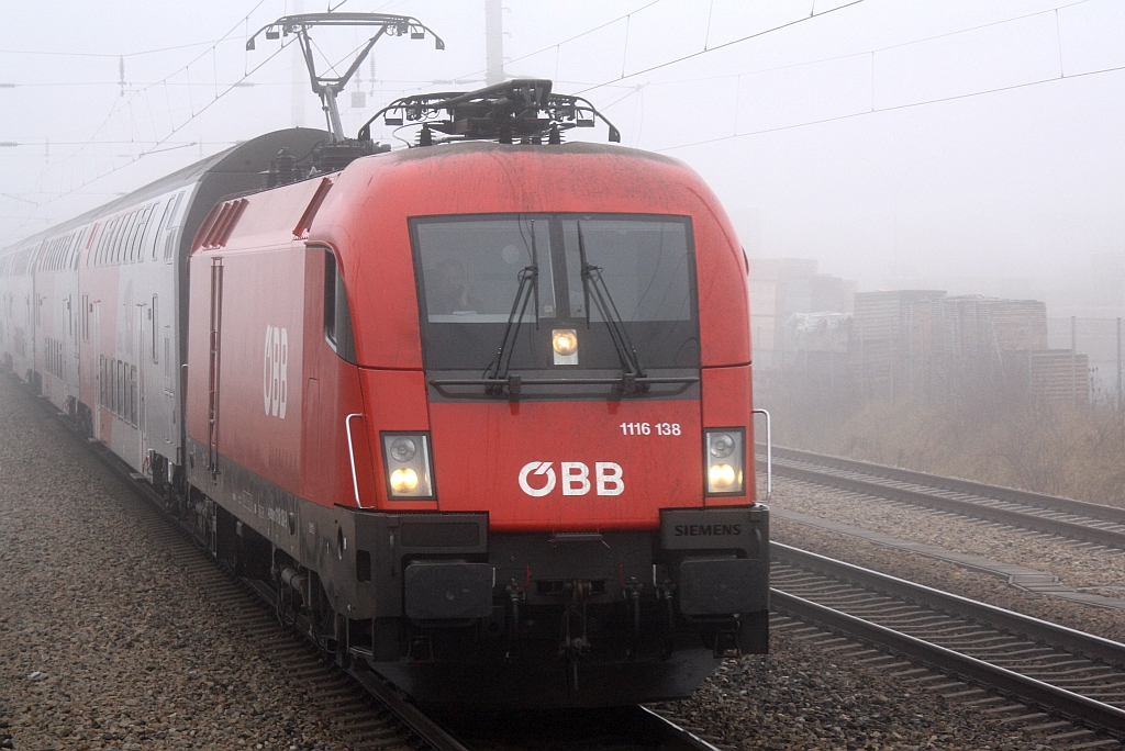 1116 138-9 fährt am 19.Dezember 2015 im dichtem Nebel mit dem R 2331 durch Brunn-Maria Enzersdorf Nord. Aufgenommen von der Plattform des letzten Wagen des SR 14051.