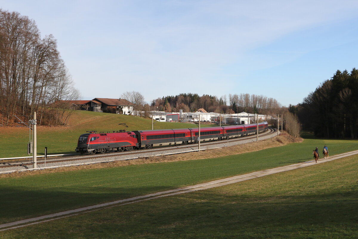 1116 152 mit einem  Railjet  aus Salzburg kommend am 28. Dezember 2023 bei Axdorf im Chiemgau.