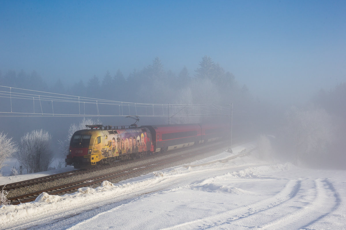 1116 153  ÖAMTC  fährt bei sich langsam auflösendem Nebel mit einem RJ bei Grabenstätt in Richtung Innsbruck, aufgenommen am 28. Januar 2017.