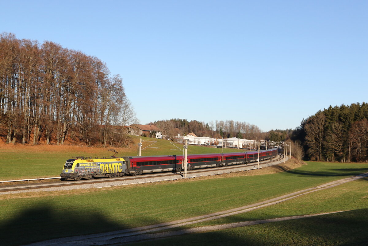1116 153  ÖAMTC  mit einem  Railjet  aus Salzburg kommend am 18. Dezember 2023 bei Axdorf im Chiemgau.