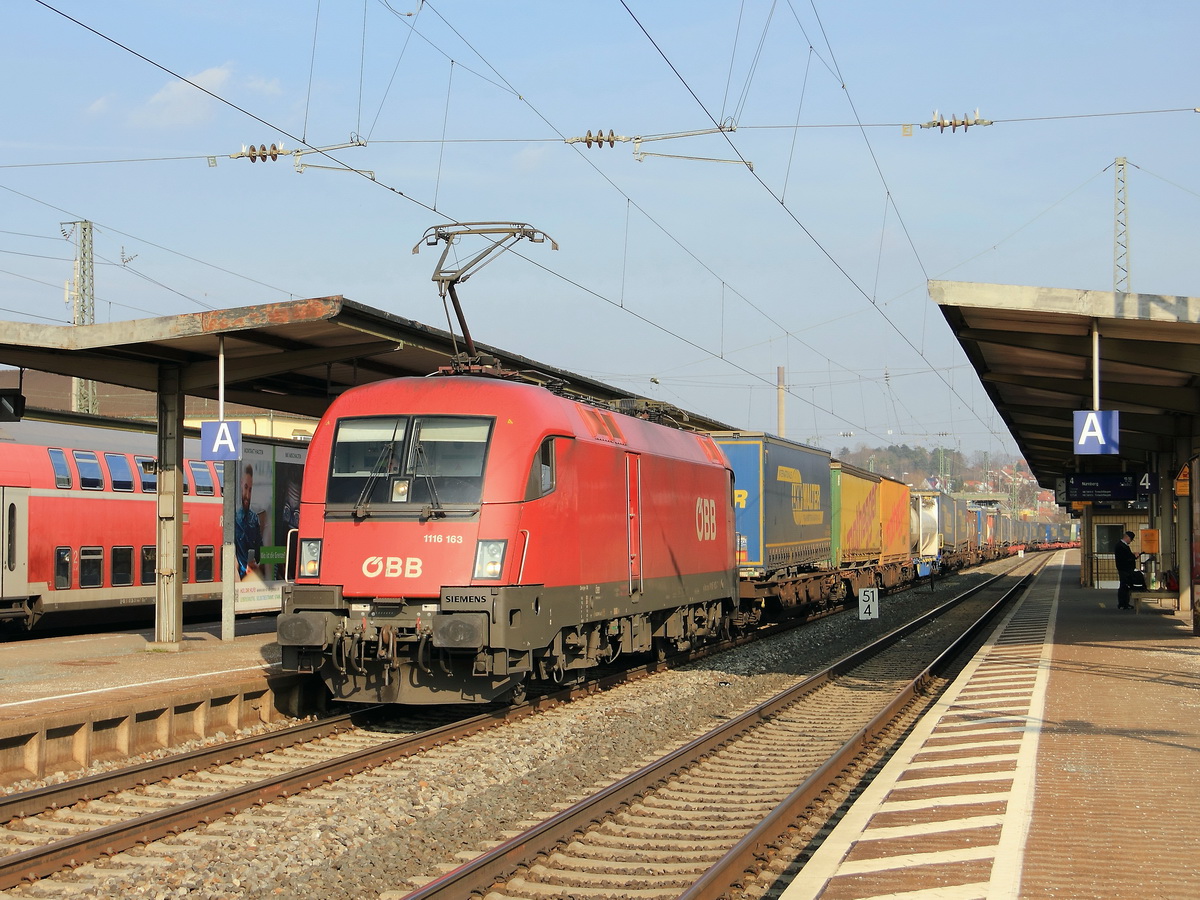 1116 163 durchfährt den Bahnhof von Ansbach mit einem Containerzug am 14. März 2017.