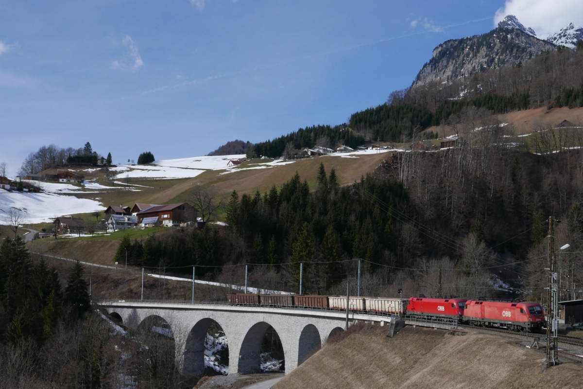 1116 169 und 1016 012 fahren mit dem aus fünf Eanos-Wagen gebildeten Güterzug über die Hölltobel-Brücke in Dalaas (27.02.2016).