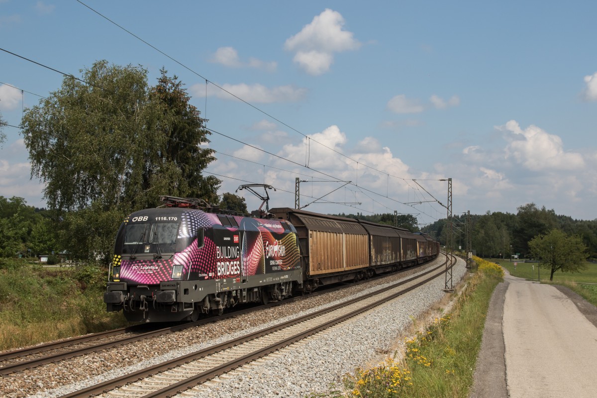 1116 170  Eurovision Song Contest  mit einem Güterzug am 18. August 2015 bei Stephanskirchen.