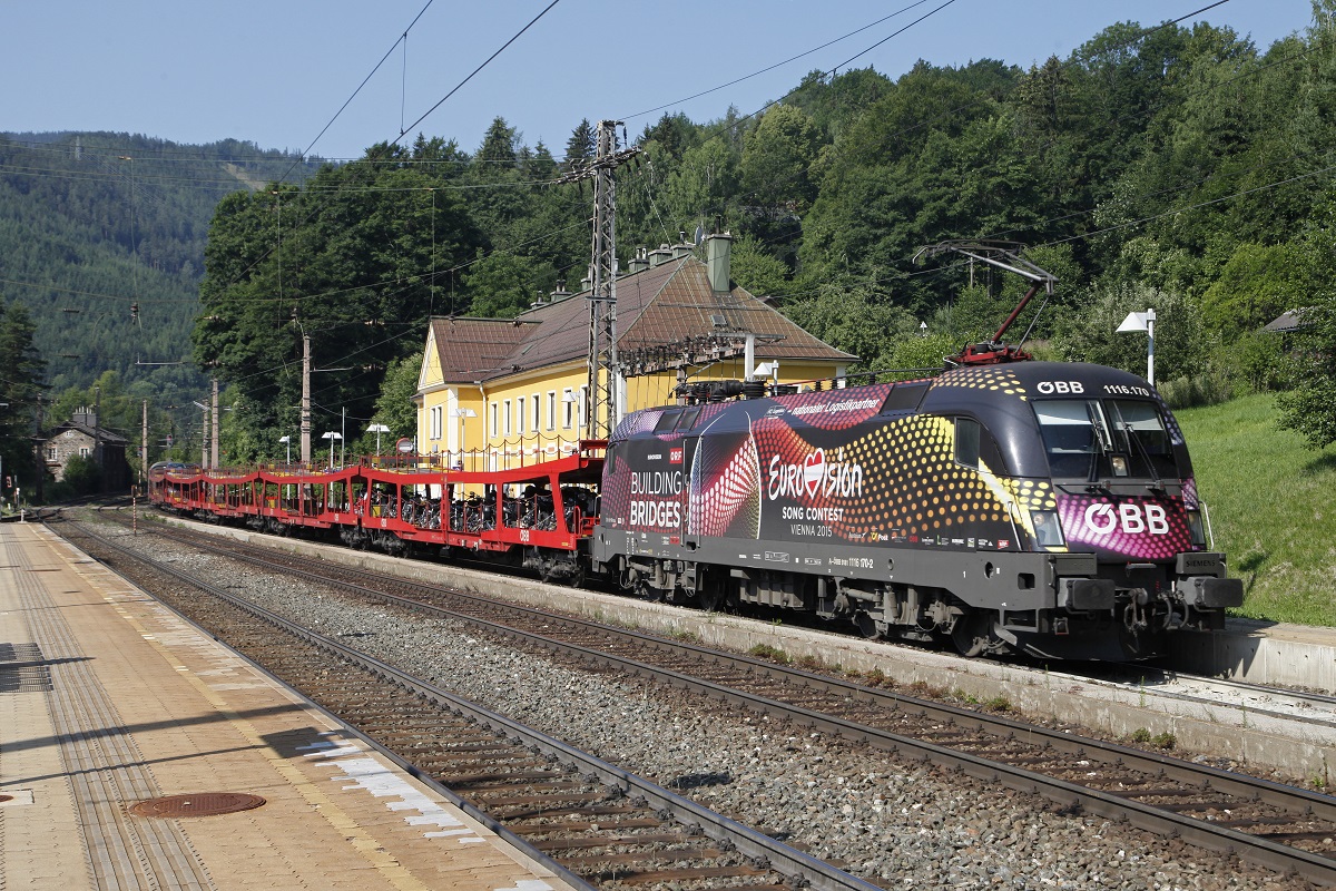 1116 170 mit D1236 in Breitenstein am 17.07.2015. Der Zug befördert fünf Autotransportwagen die an der Zugspitze gereiht sind. Dahinter ist der erste Reisezugwagen gerade noch zu erkennen.