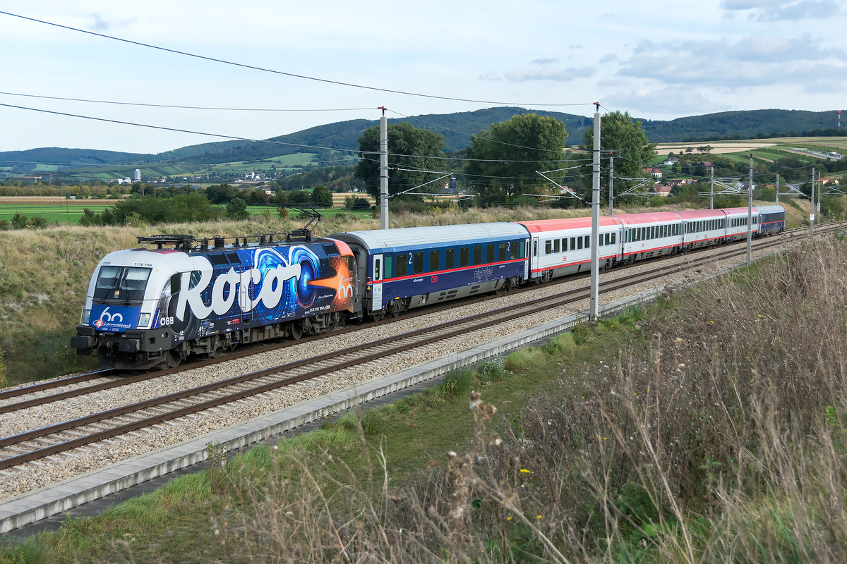 1116 199,  60 Jahre Roco , unterwegs mit dem D 722 von Wien Hbf. nach Linz Hbf. am 06.10.2020 kurz nach dem Verlassen des Westportals des Wienerwaldtunnels.