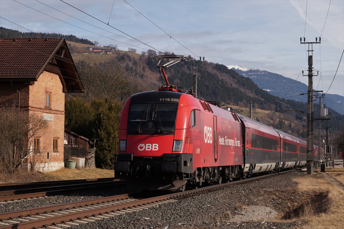 1116 225 betreibt Eigenwerbung für die ÖBB, als sie am 24.02.2020 auf der Drautalbahn mit dem rj596 'Gasteinertal' (Flughafen Wien - Klagenfurt) in Richtung Villach unterwegs ist. Gerade hat der Zug den Bahnhof Rothenthurn durchfahren. 