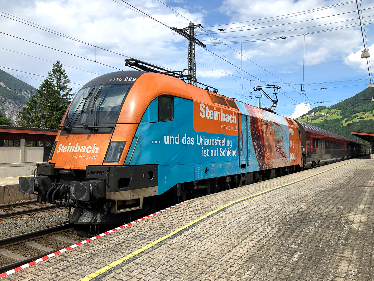 1116 229  Steinbach - we are pool  mit RJX 169 nach Wien Hbf am ganz letzten Zacken des Bahnsteigs 2. Der doppelte Zug füllte fast den ganzen 500 Meter langen Bahnsteig aus. Ötztal-Bahnhhof am 27.06.2021