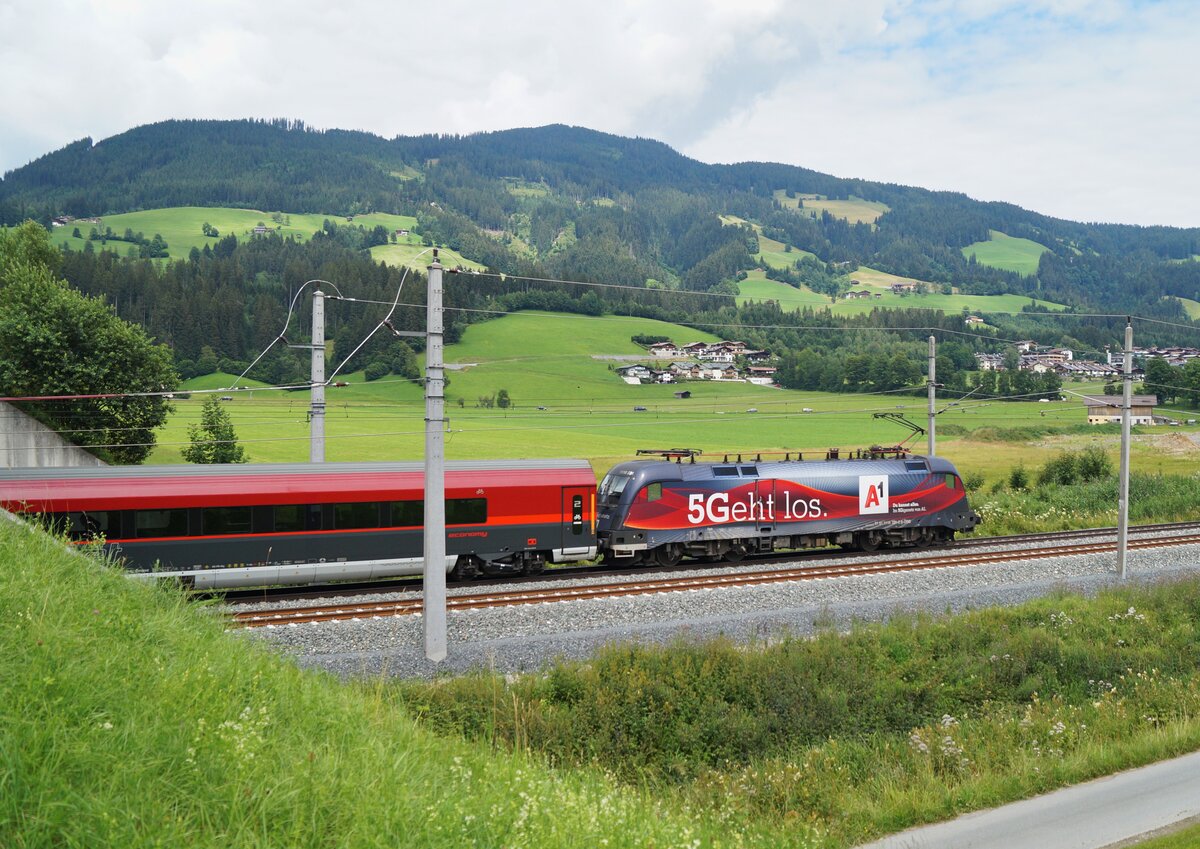 1116 231 in der A1-Beklebung mit Werbung für das  5G-Giganetz  am 25.07.2020 am RJX 1262  Kitzbüheler Alpen  (Wien Hbf - Wörgl Hbf) bei Kirchberg in Tirol.