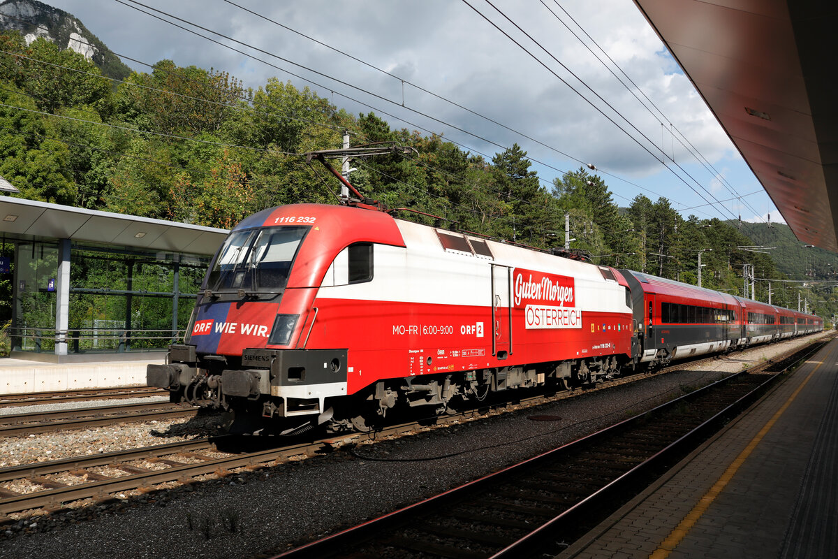 1116 232  Guten Morgen Österreich  schiebt eine Railjet Garnitur vom Semmering kommend Richtung Gloggnitz durch den Bahnhof Payerbach Reichenau.