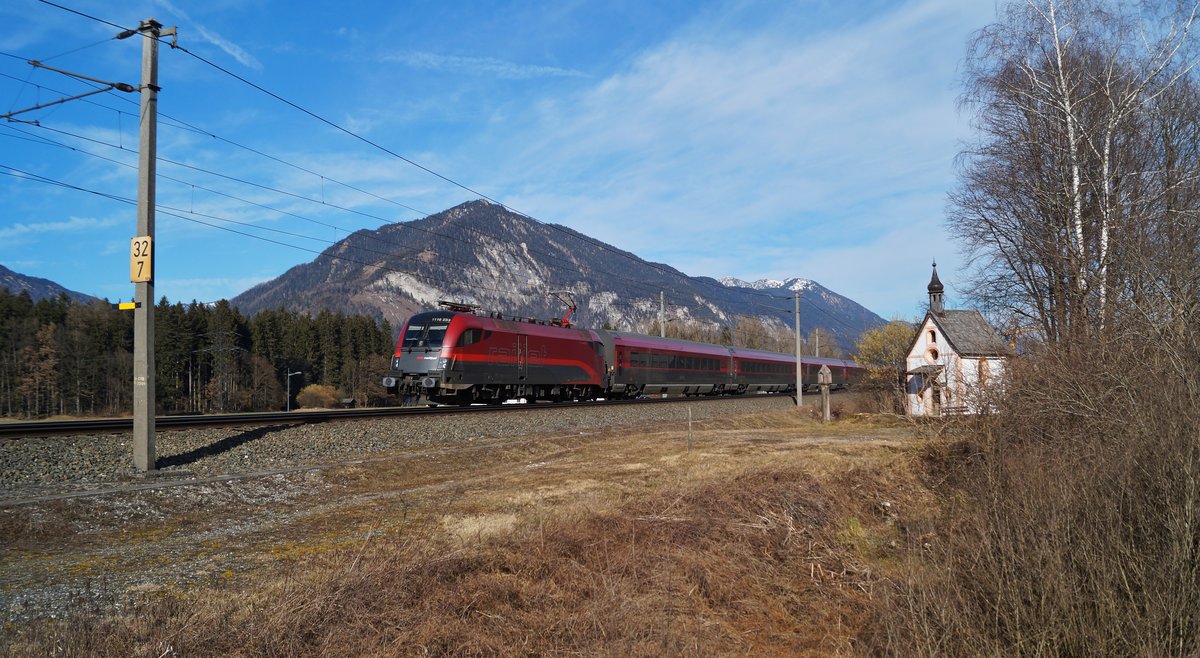 1116 233 hatte am 22.02.2020 den RJX 860 nach Bregenz am Haken und passierte in der nachmittäglichen Spätwintersonne die Antoniuskapelle bei Brixlegg.