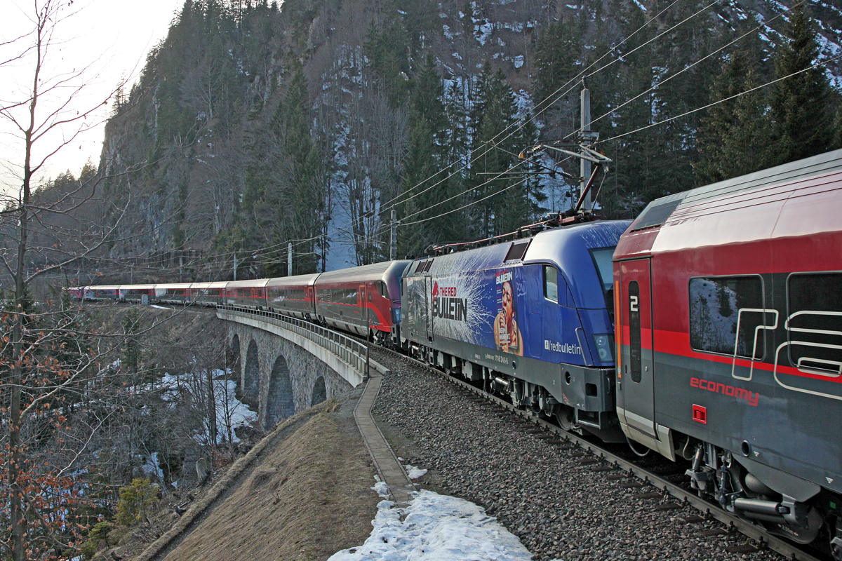 1116 248 schiebt abends den 13.3.2015 in der Zugmitte einen RJ bergwärts uber das Radonnabachviadukt,Länge 80m.Bild in Wald am Arlberg