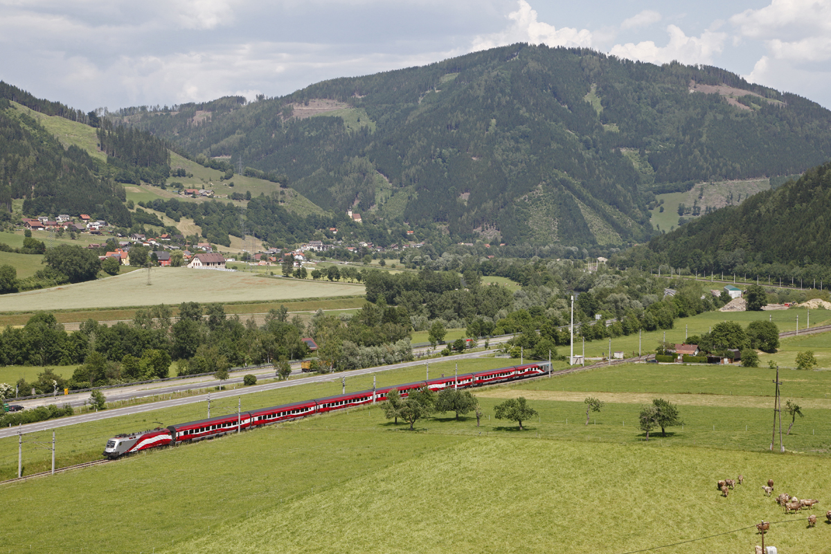 1116 249 (Lange Fahne) ist am 11.06.2014 als Railjet 535 bei Niklasdorf durchs Murtal unterwegs.