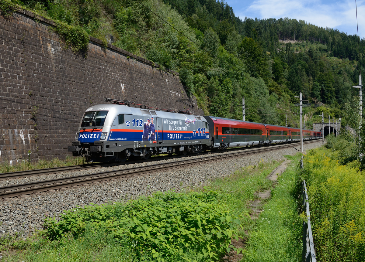 1116 250  Polizei  war am 11.08. mit dem RJ 533 nach Villach unterwegs, und wurde von mir auf der Verbindungsbahn Bruck/Mur-St.Michael zwischen dem Galgenberg- und Annabergtunnel fotografiert. 